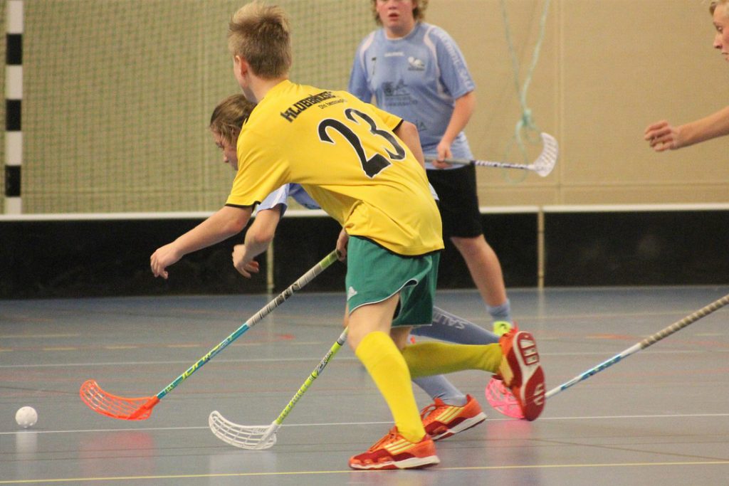 Barn som spelar innebandy.