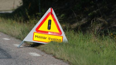 En skylt i en vägkant som varnar för en militär övning.